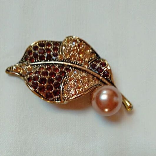 Broche bisuteria en forma de hoja cuajado de piedras en tonos marrones .Nuevo